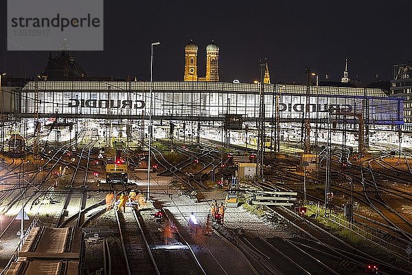 Beleuchteter Hauptbahnhof mit Gleisen bei Nacht  hinter der Frauenkirche  München  Deutschland  Europa