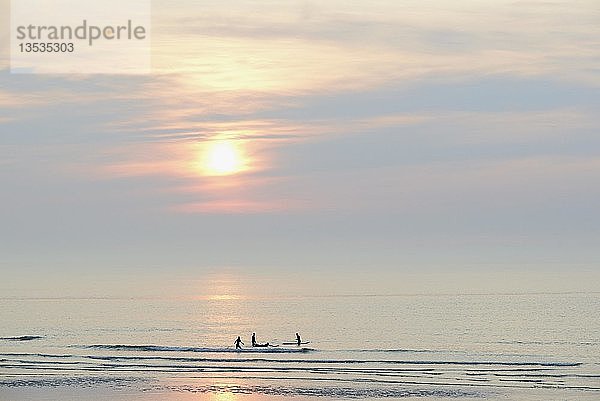 Silhouettten  Surfer auf der ruhigen Nordsee am Abend  Norderney  Ostfriesische Inseln  Niedersachsen  Deutschland  Europa