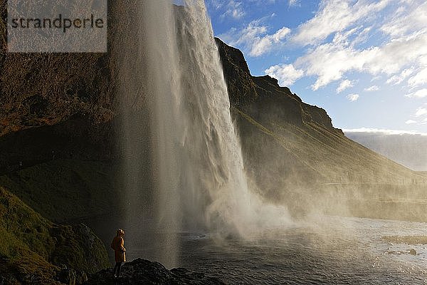 Stehende Person am Seljalandsfoss-Wasserfall  Südisland  Island  Europa