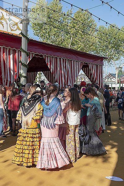 Spanische Frauen mit bunten Flamenco-Kleidern vor Festzelten  Casetas  Feria de Abril  Sevilla  Andalusien  Spanien  Europa