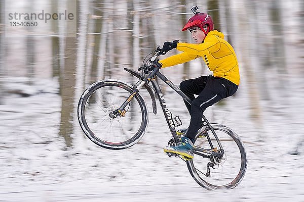 Junge  14 Jahre alt  Mountainbike fahren im Wald im Schnee  Baden-Württemberg  Deutschland  Europa