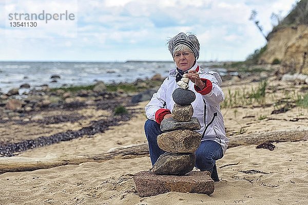 Frau baut einen Steinhaufen am Strand  Timmendorf auf der Insel Poel  Mecklenburg-Vorpommern  Deutschland  Europa