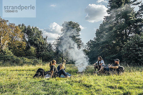 Freunde zelten  Entspannung am Lagerfeuer in einem abgelegenen Feld