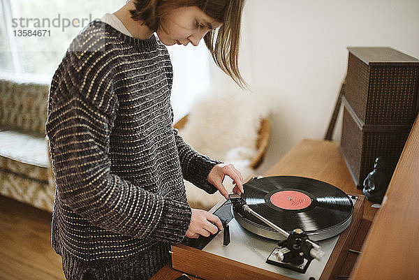 Mädchen spielt Schallplatte im Wohnzimmer
