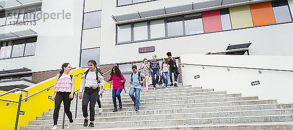 Schüler der Mittelstufe verlassen das Schulgebäude und steigen die Treppe hinunter