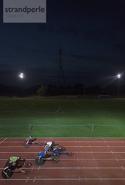 Querschnittsgelähmte Athleten rasen bei einem nächtlichen Rollstuhlrennen über eine Sportstrecke