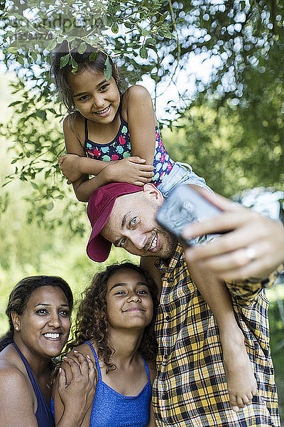 Glückliche  liebevolle Familie macht Selfie mit Fotohandy