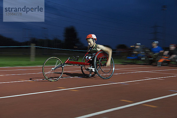 Jugendlicher querschnittsgelähmter Sportler rast im Rollstuhlrennen über die Sportstrecke