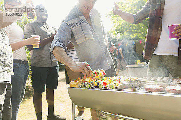 Männliche Freunde beim Grillen im Hinterhof