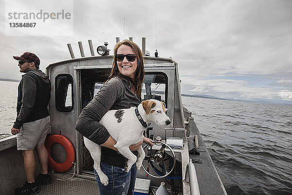 Porträt lächelnde Frau mit Hund auf Fischerboot