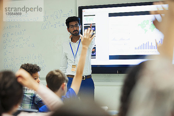 Lehrer leitet den Unterricht  ruft die Schüler im Klassenzimmer auf