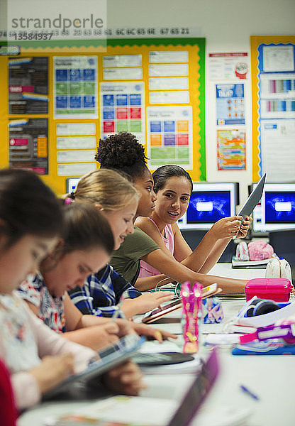 Schülerin der Junior High School verwendet digitale Tablets am Schreibtisch im Klassenzimmer