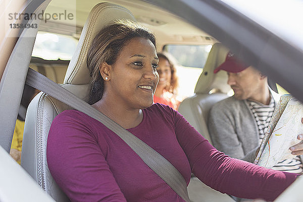 Lächelnde Frau  die mit ihrer Familie auf einer Autoreise Auto fährt