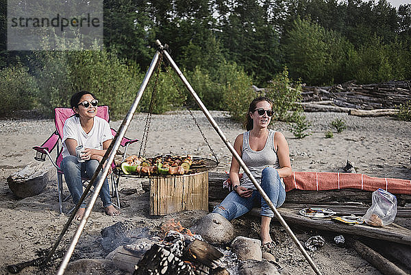 Frauen entspannen sich  genießen das Barbecue am Strand
