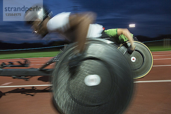 Querschnittsgelähmte Athleten rasen bei einem nächtlichen Rollstuhlrennen über eine Sportstrecke