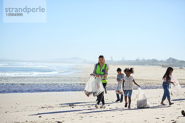 Freiwillige Kinder säubern den Strand von Abfällen