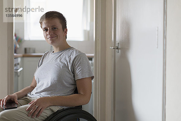 Porträt selbstbewusste junge Frau im Rollstuhl zu Hause