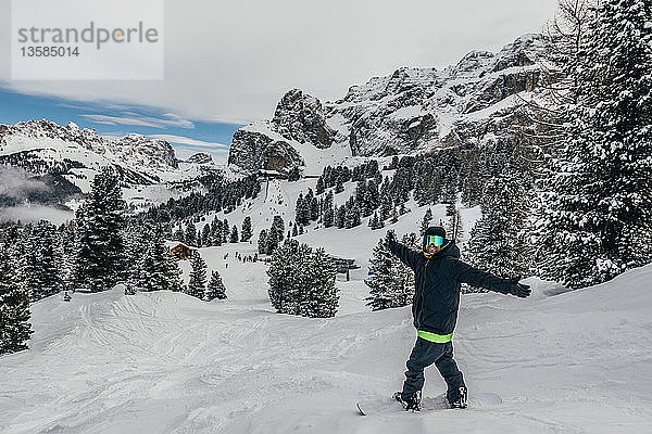 Porträt übermütiger Snowboarder auf verschneiter Skipiste  Dolomiten  Italien