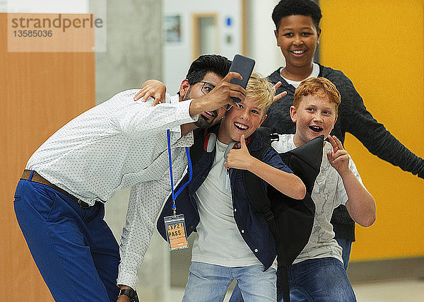 Schüler der Junior High und männlicher Lehrer machen Selfie mit Smartphone