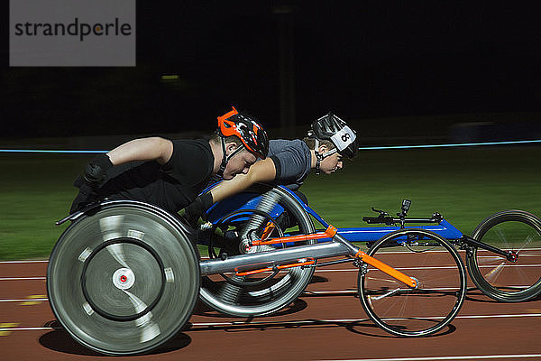 Querschnittsgelähmte Athleten rasen bei einem nächtlichen Rollstuhlrennen über die Sportstrecke