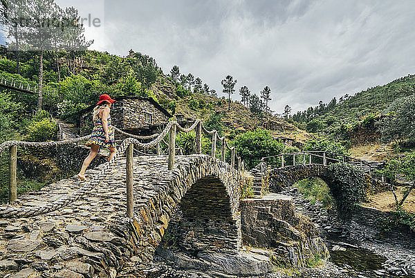Frau geht über eine idyllische Steinbrücke  Chas de Egua  Portugal