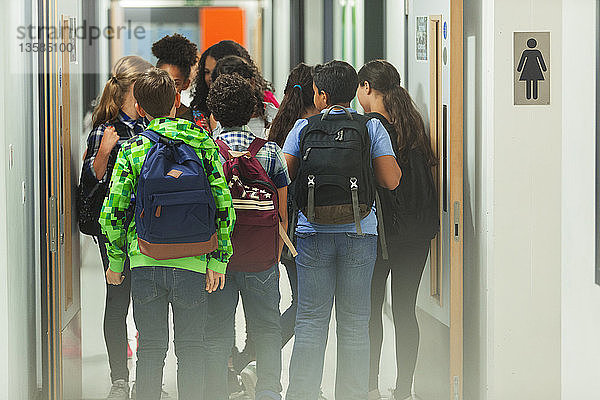 Gymnasiasten mit Rucksäcken auf dem Schulflur