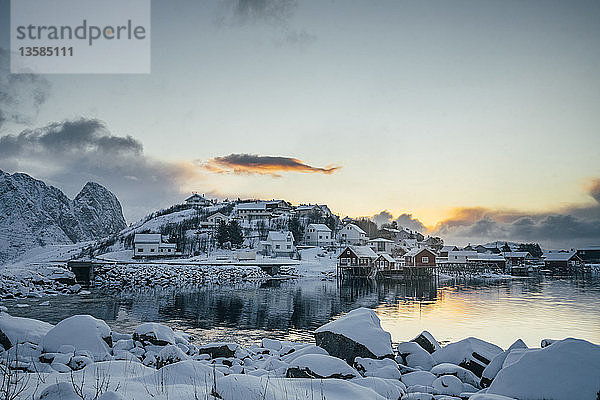 Beschauliches  schneebedecktes Fischerdorf am Wasser  Reine  Lofoten  Norwegen