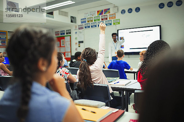 Schüler der Junior High School hebt die Hand und stellt eine Frage während des Unterrichts im Klassenzimmer