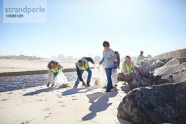 Freiwillige beseitigen Müll am sonnigen Strand