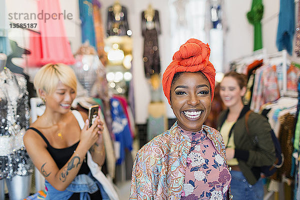 Porträt begeisterte junge Frau beim Einkaufen mit Freunden in einem Bekleidungsgeschäft