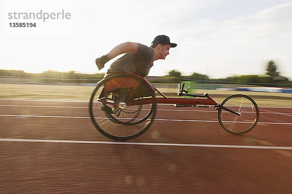 Jugendlicher querschnittsgelähmter Sportler rast im Rollstuhlrennen über die Sportstrecke