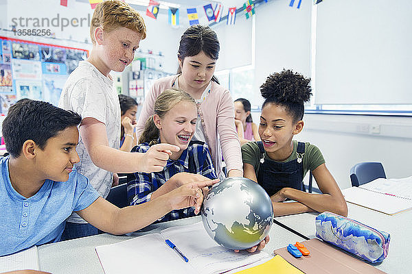 Neugierige Schüler der Junior High School betrachten den Globus im Klassenzimmer