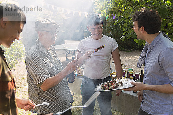 Männliche Freunde beim Grillen im Hinterhof