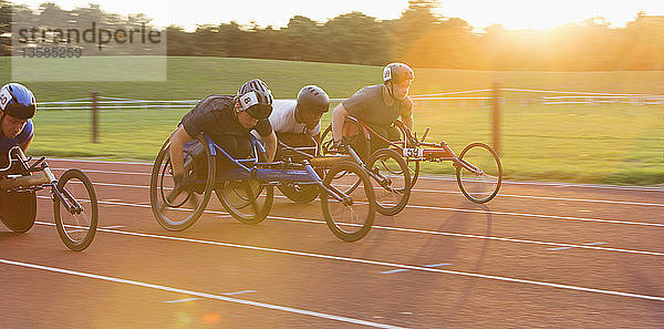 Entschlossene querschnittsgelähmte Athleten rasen im Rollstuhlrennen über die Sportstrecke