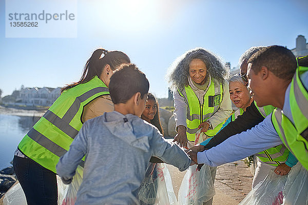 Freiwillige  die sich zusammenschließen  um den Müll am sonnigen Strand zu beseitigen