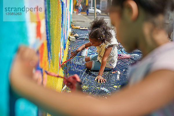 Mädchen malen Wandbilder an der Wand