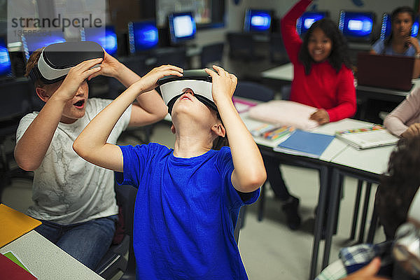 Neugierige Jungen der Junior High School nutzen Virtual-Reality-Simulatoren im Klassenzimmer