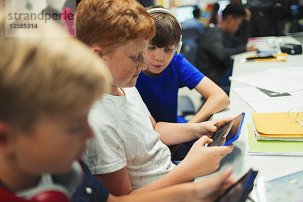 Jungen der Sekundarstufe II nutzen ein digitales Tablet im Klassenzimmer