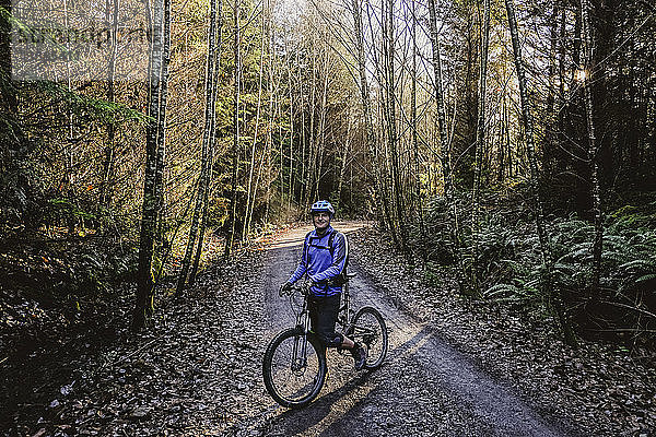 Porträt selbstbewusster Mann beim Mountainbiking im Herbstwald  Squamish  BC  Kanada