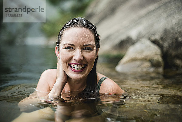Porträt lächelnd  schöne junge Frau schwimmt im See