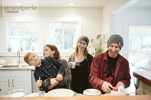 Porträt einer fröhlichen  verspielten Familie beim Backen in der Küche