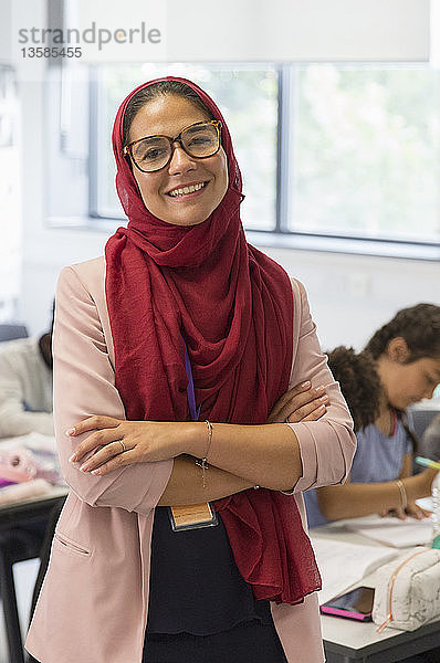 Porträt einer selbstbewussten Lehrerin mit Hidschab im Klassenzimmer
