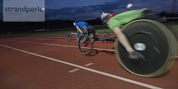 Querschnittsgelähmte Athleten rasen bei einem nächtlichen Rollstuhlrennen über eine Sportstrecke