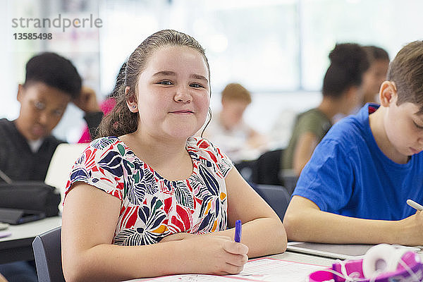 Portrait lächelnd  zuversichtlich Junior High School Mädchen studieren im Klassenzimmer