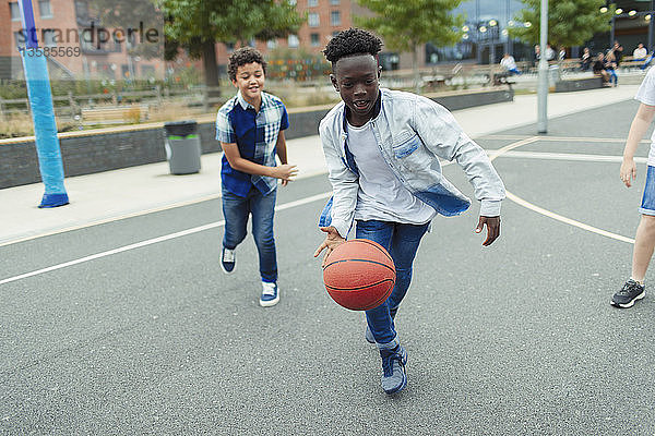 Zwei Jungen spielen Basketball auf dem Schulhof