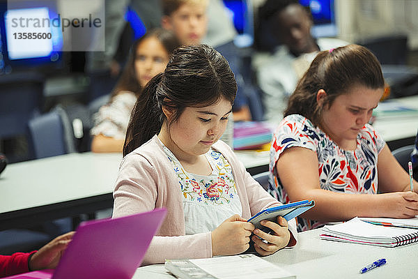 Fokussierte Schülerin der Junior High School  die ein digitales Tablet im Klassenzimmer benutzt