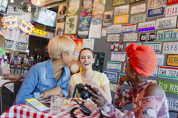 Junge Frauen Freunde mit Digitalkamera in einer Bar