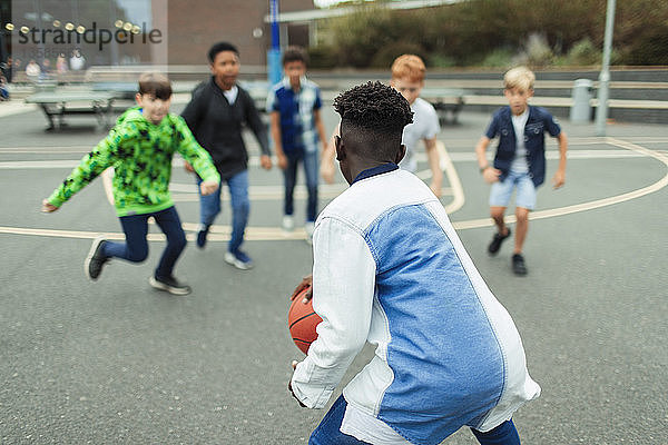 Zwei Jungen spielen Basketball auf dem Schulhof