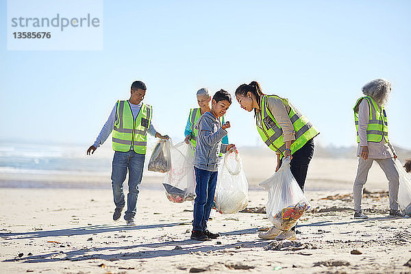 Freiwillige beseitigen Müll am sonnigen Sandstrand