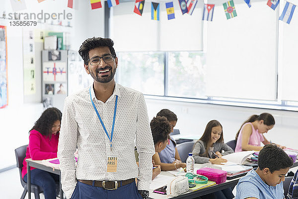Porträt lächelnder  selbstbewusster männlicher Lehrer im Klassenzimmer